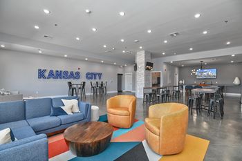 a living room with couches and chairs in front of a bar and a tv